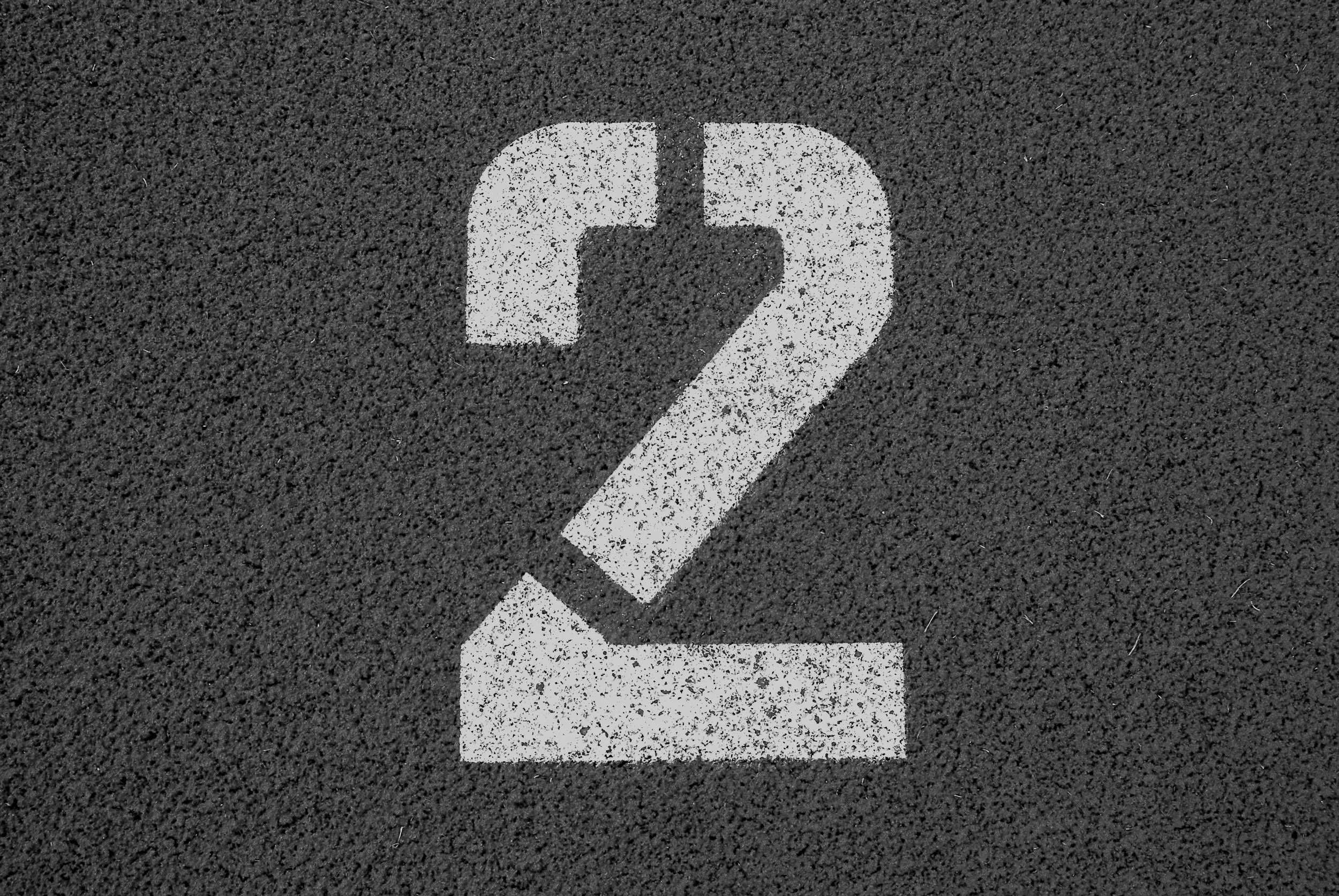 A white painted number 2 on a dark asphalt surface