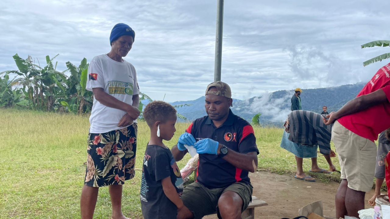  In Kagi, Mt Koiari catchment along the Kokoda Track, Br Desmond Taboeya conducts “ear mopping” for a child with discharge. 