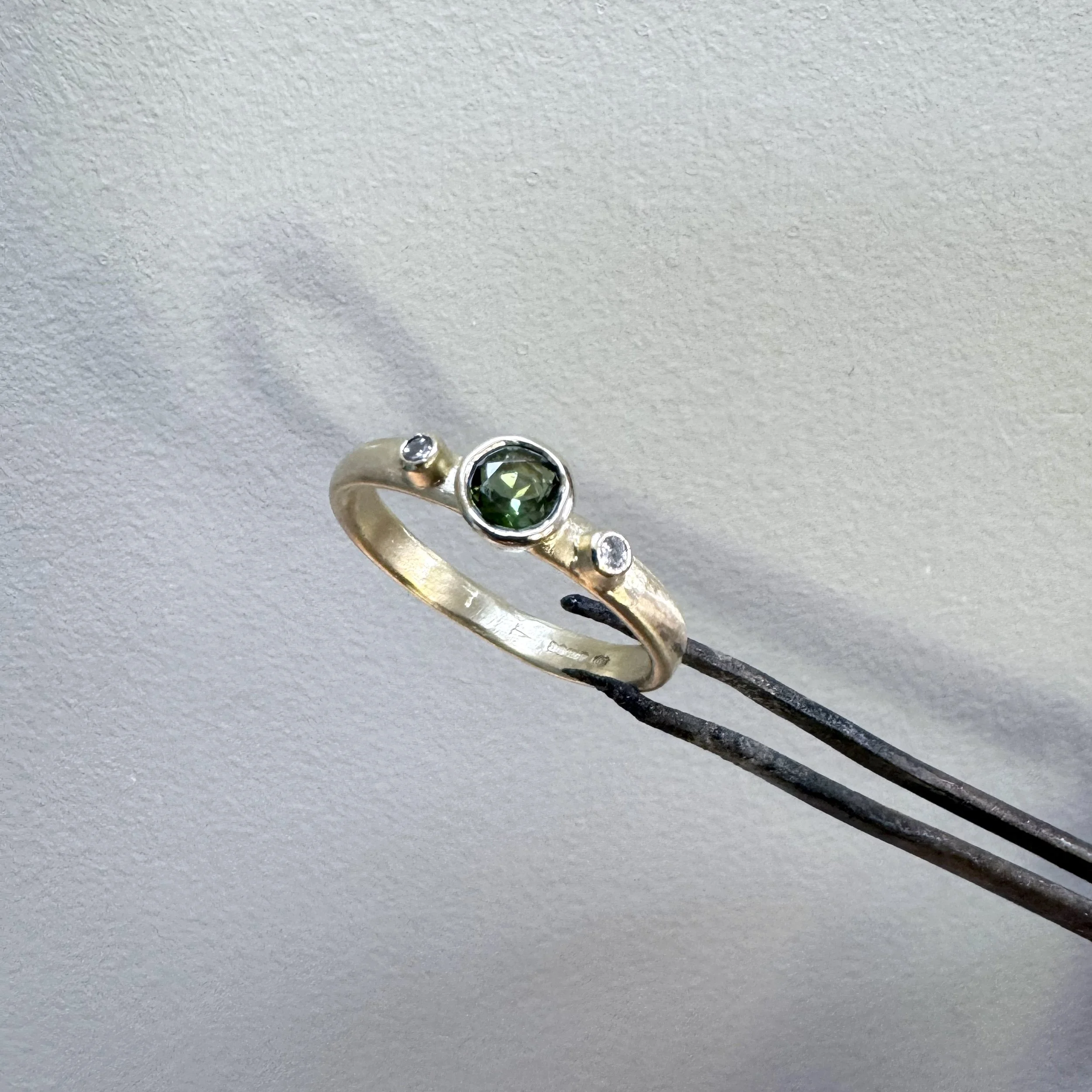 9ct golg ring set with a central tourmaline and diamonds either side