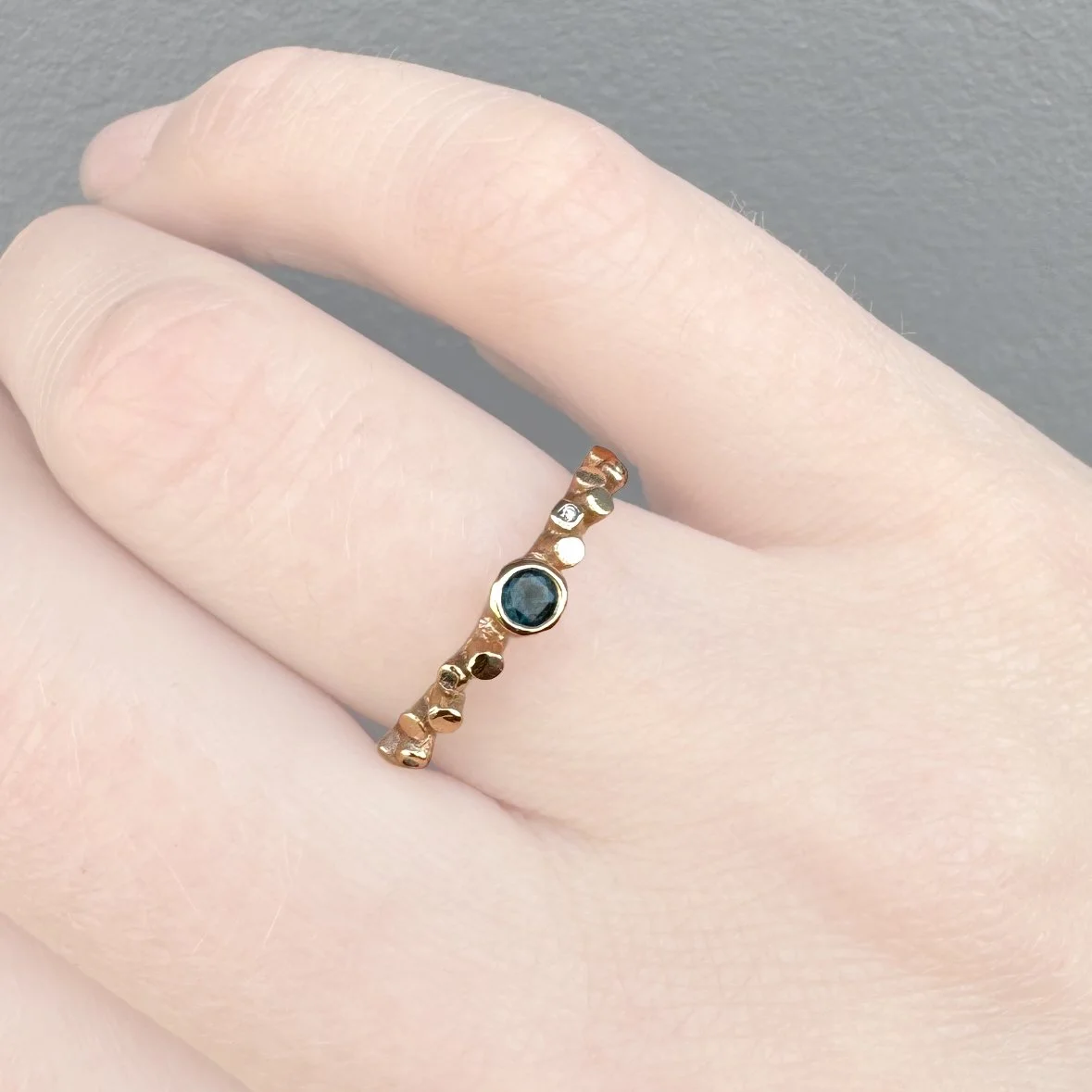 9ct Scatter gold ring set with a sapphire and small diamonds scattered either side