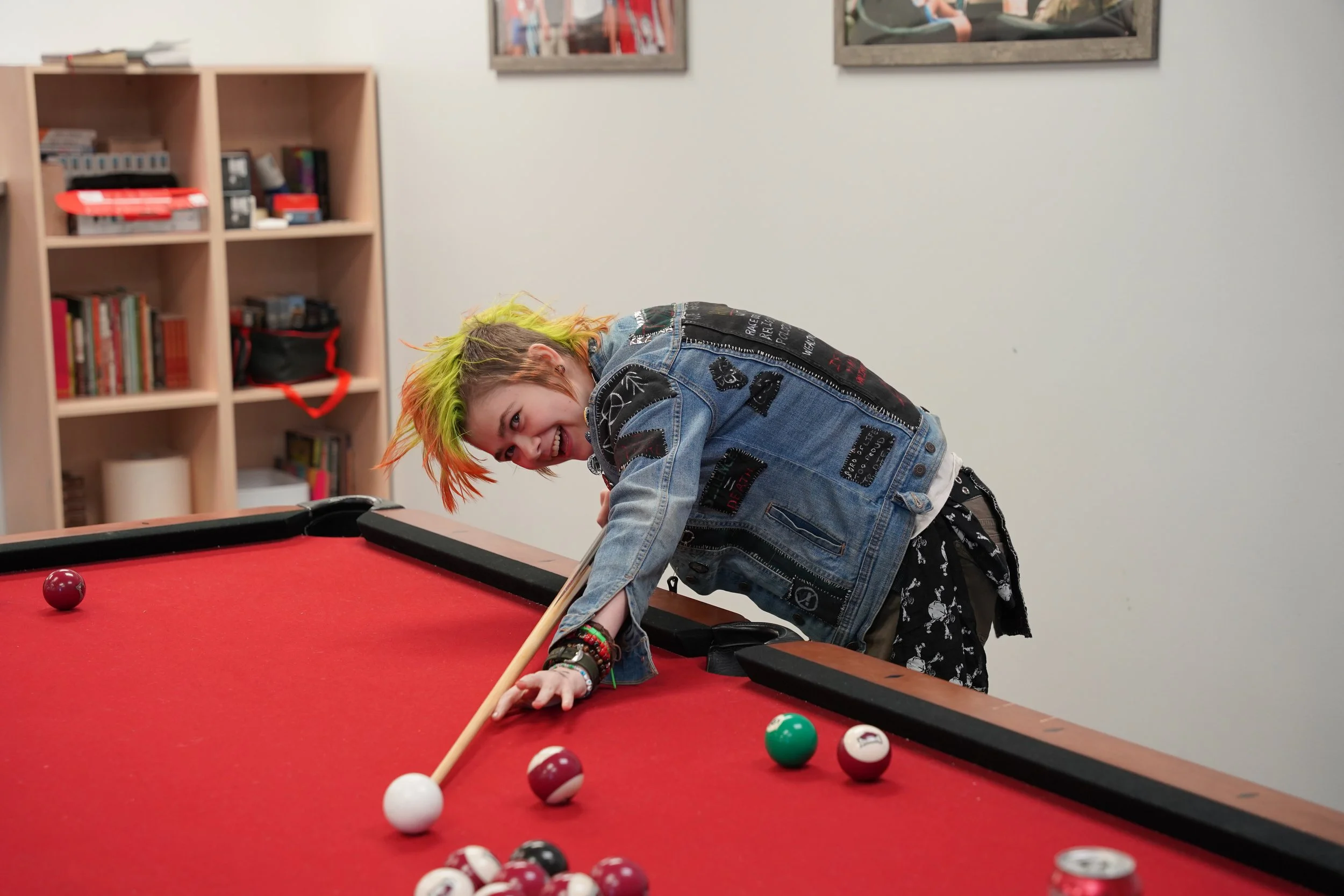 teenage girl smiling playing pool