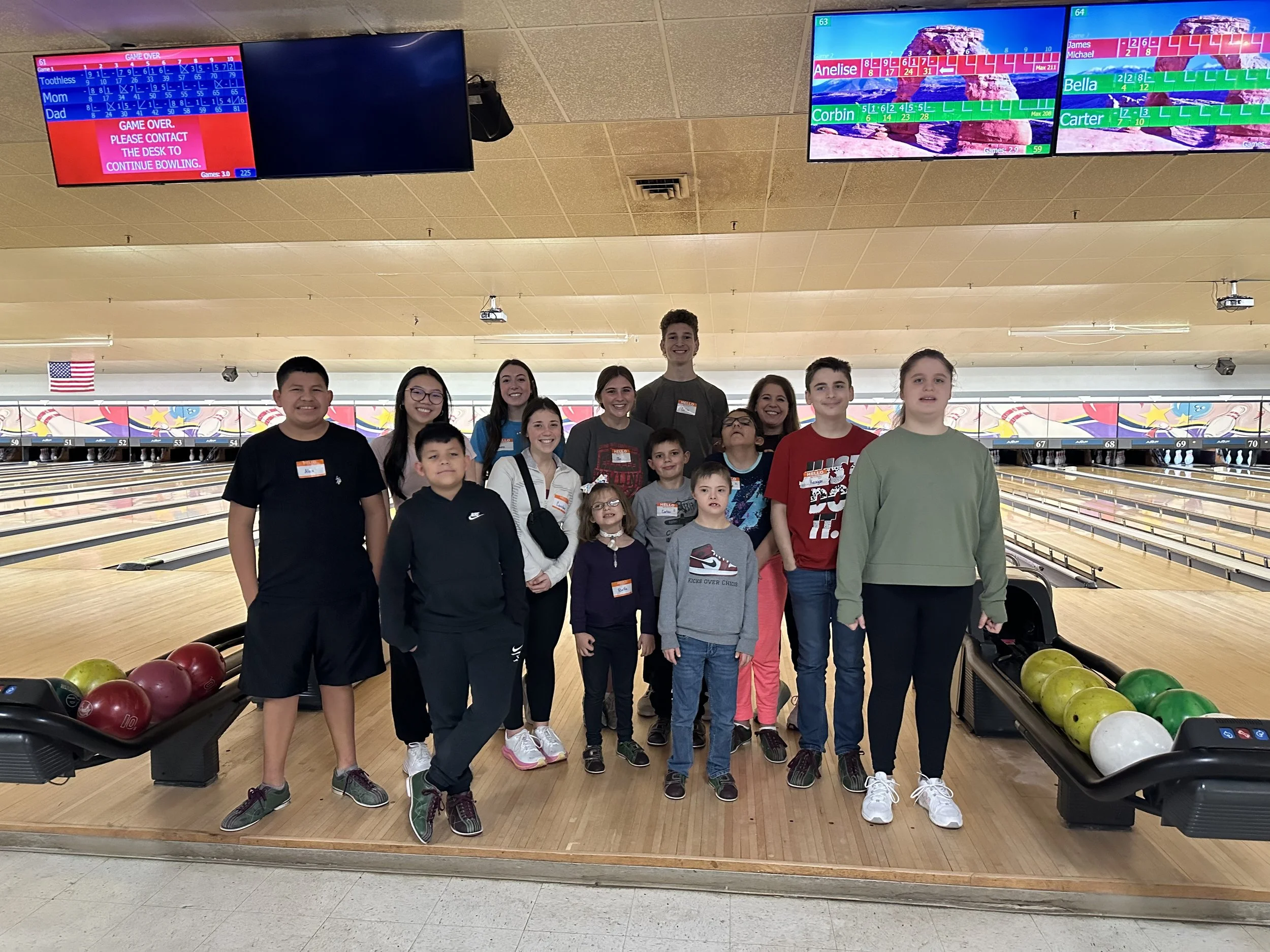 children and volunteers posing in a bowling alley