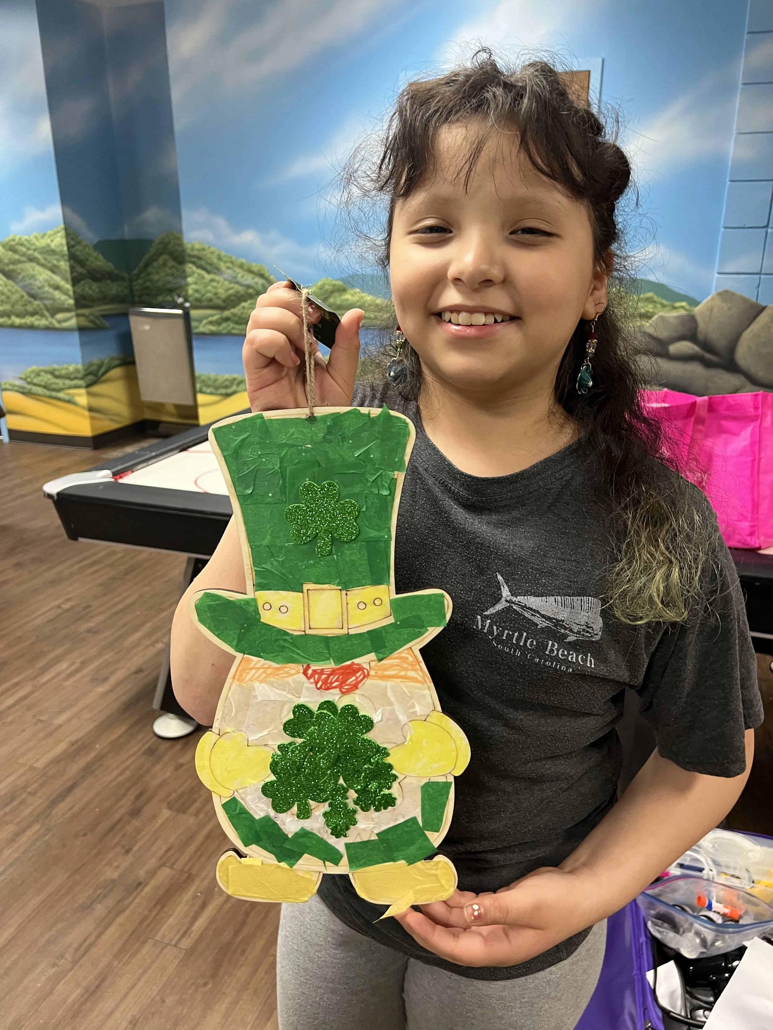 hispanic girl showing a leprechaun art project
