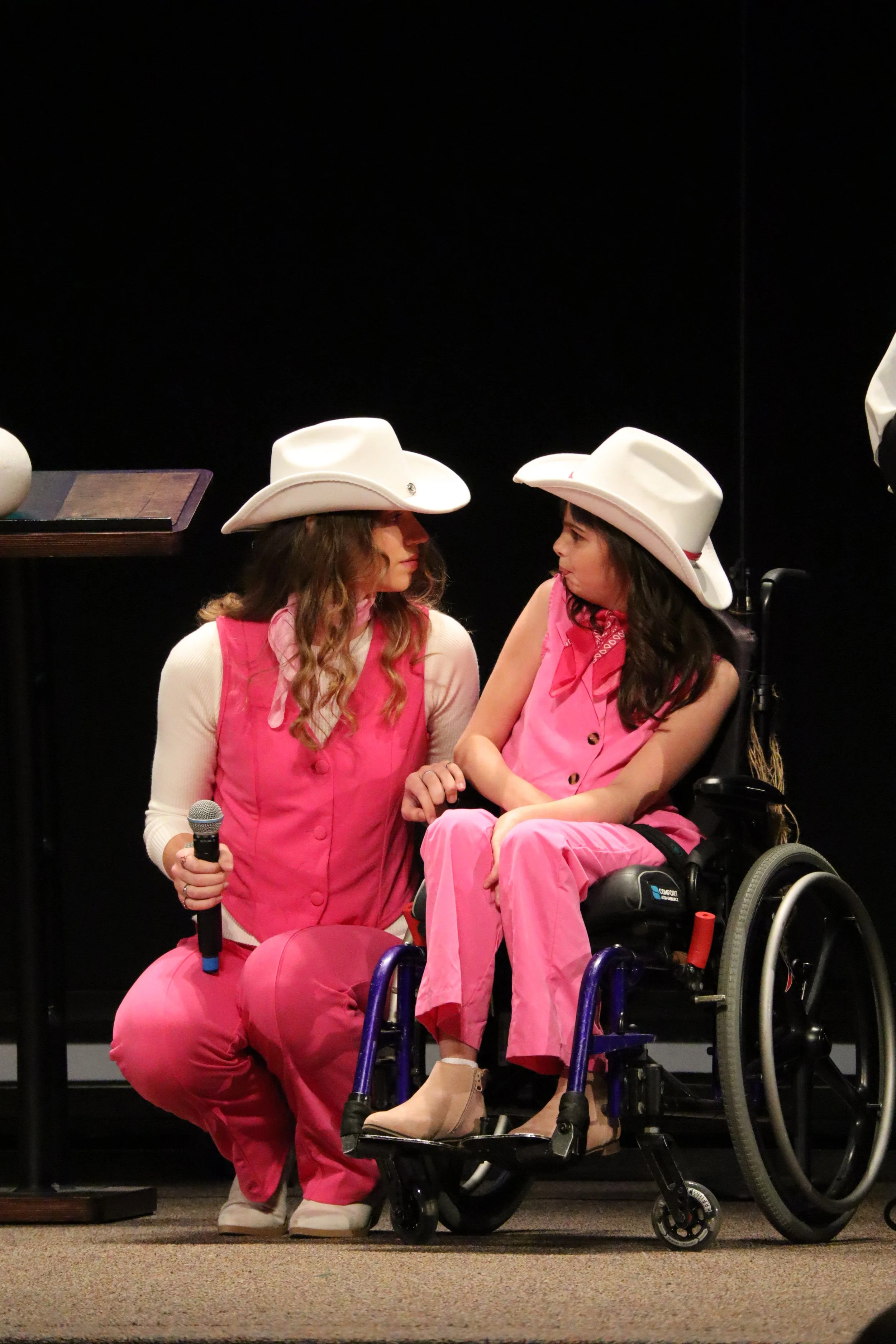 a volunteer & girl wheelchair wearing cowgirl costumes