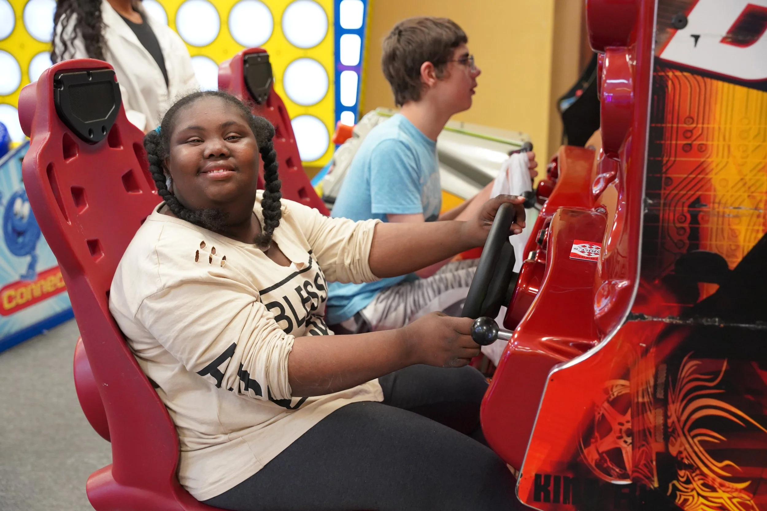 teenage boy and girl at arcade driving game