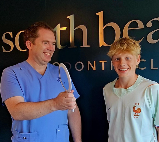 Smiling orthodontic patient sharing his teeth straightening experience