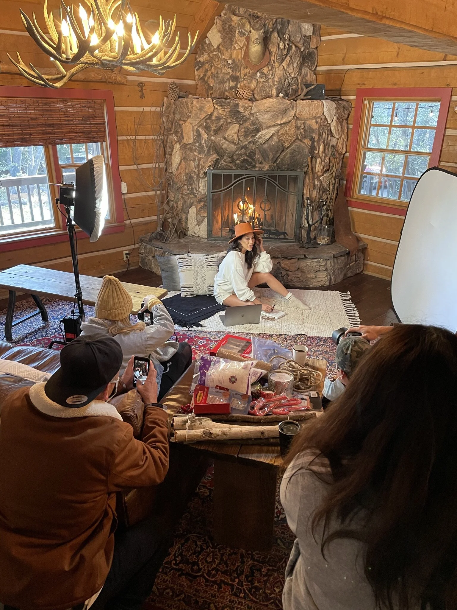 Behind the scenes production at a lifestyle shoot at a cabin in Julian California. There is a photographer, wardrobe stylist model and ecommerce manager. 