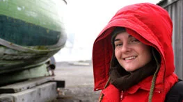 Erika joins the YERT trip to help out after Julie leaves to prepare for the baby.

Image: a young white woman in a hooded red jacket smiling pleasantly