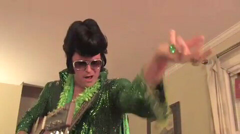 Eco Elvis, heartthrob of greenies everywhere

Image: an Elvis impersonator with a dark wig, sunglasses, and a green sequined suit. He is holding a guitar, and his hand is extended performatively.