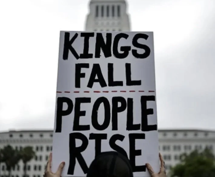 Sign reading "Kings Fall -- People Rise"