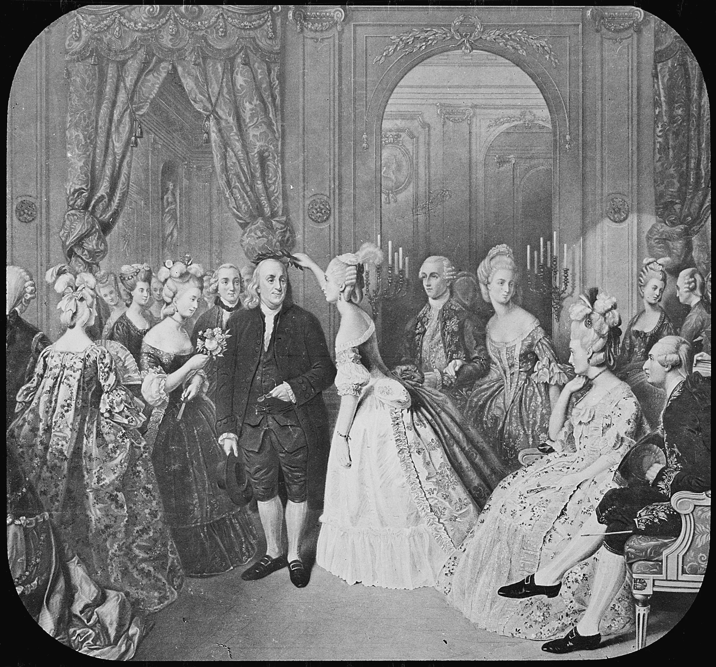 Black and white engraving of Benjamin Franklin in the center of the room with mostly women in the 18th century French court surrounding him. One places a laurel wreath on his head.