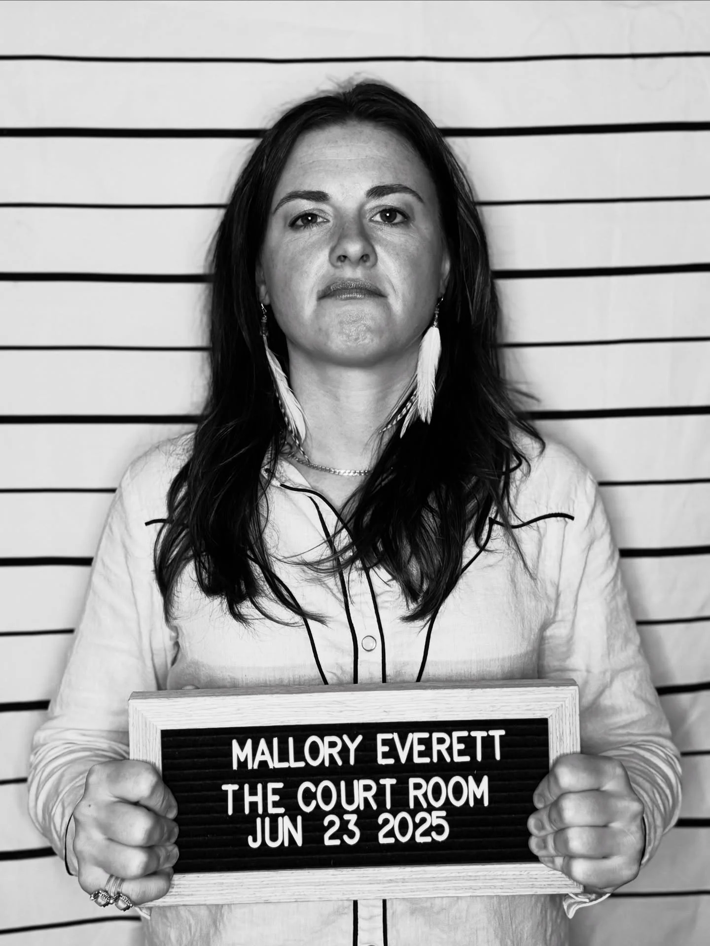 MALLORY EVERETT

Arraignment : 06/23/2025 7PM

Mallory Everett is a gritty outlaw country singer-songwriter from the Arkansas Delta, raised on an 8,000-acre farm and forged by hard work and heartbreak. With a raspy voice and raw lyrics, she sings lik