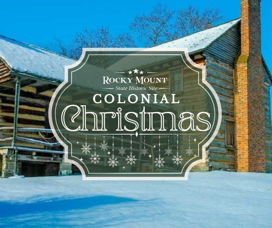 Historic log cabin with two brick chimneys in snow, under bright blue sky.
