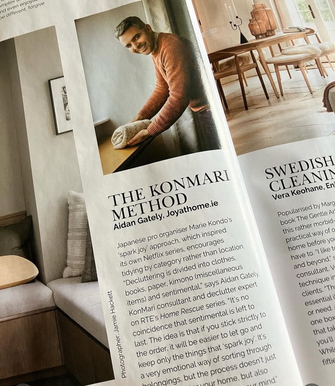 Image shows a page of a magazine with Aidan Gately in a rust coloured sweater holding a folded item of clothing, smiling at the camera. The article talks about the KonMari Method and Aidan's business Joy at Home