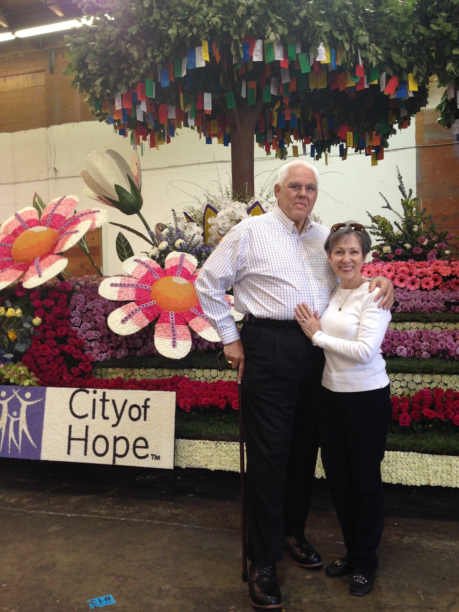 J Jon Bruno in front of the City of Hope Rose Parade float with his wife Mary