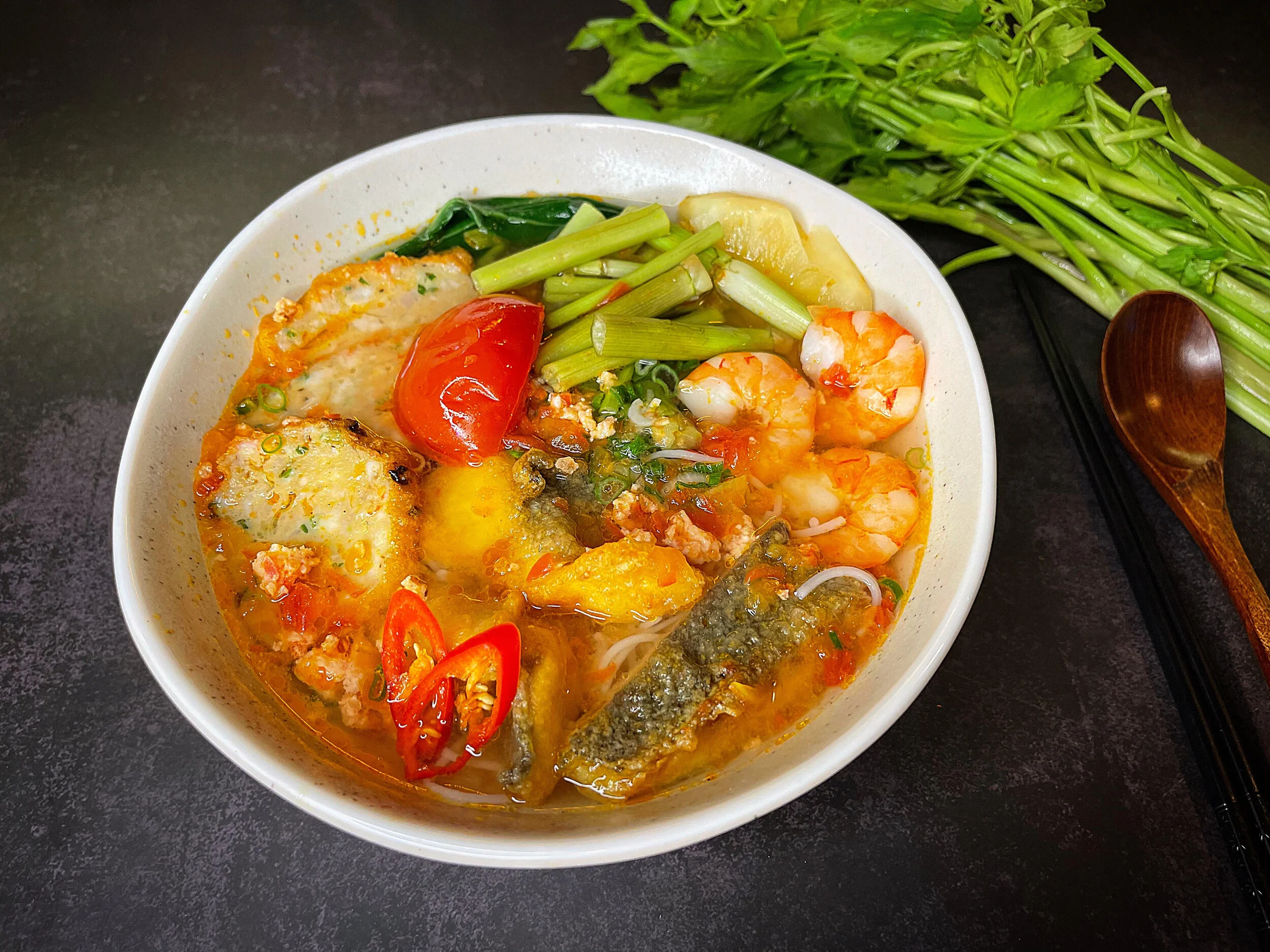 Bun Ca- sweet & sour noodle soup with fish cake, crispy sea bass, fresh prawn and vegetable