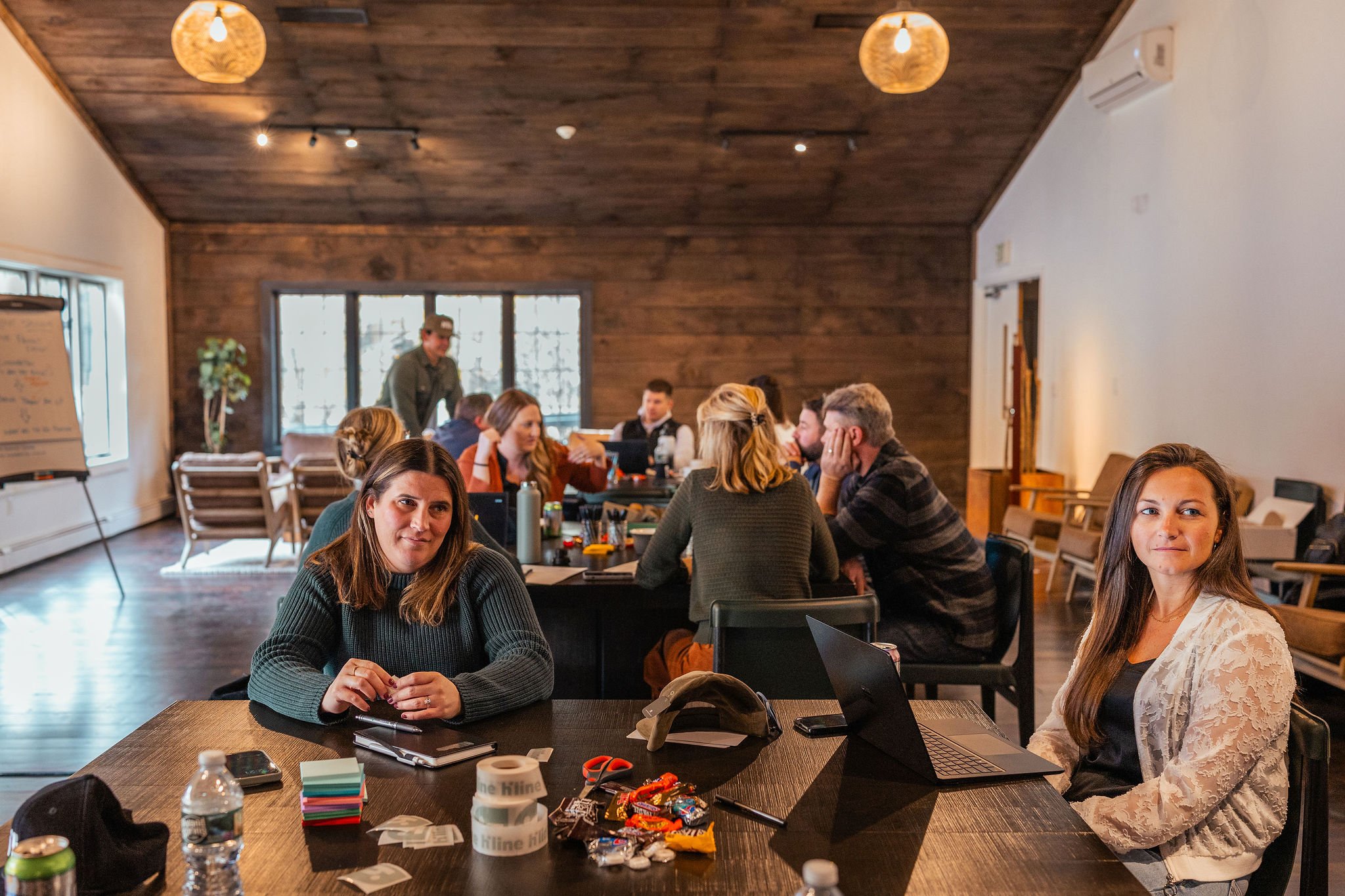 Leadership team gathered for an EOS quarterly meeting at Vanderkamp in Central New York, collaborating in a rustic lodge setting during a corporate retreat.