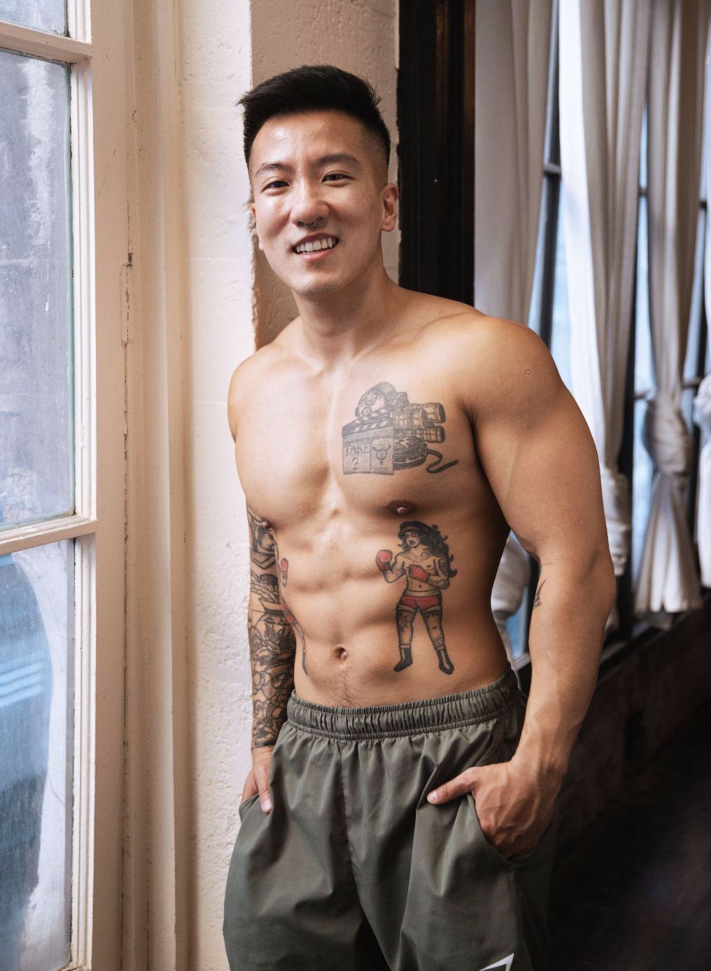 A queer person smiling and comfortable in their own skin at home.