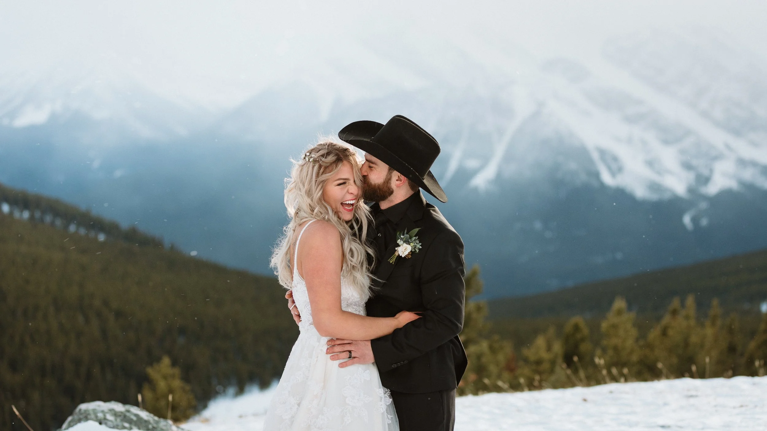 bride and groom ion a snowy mountain in Nordegg Abraham Lake Heli-elopement