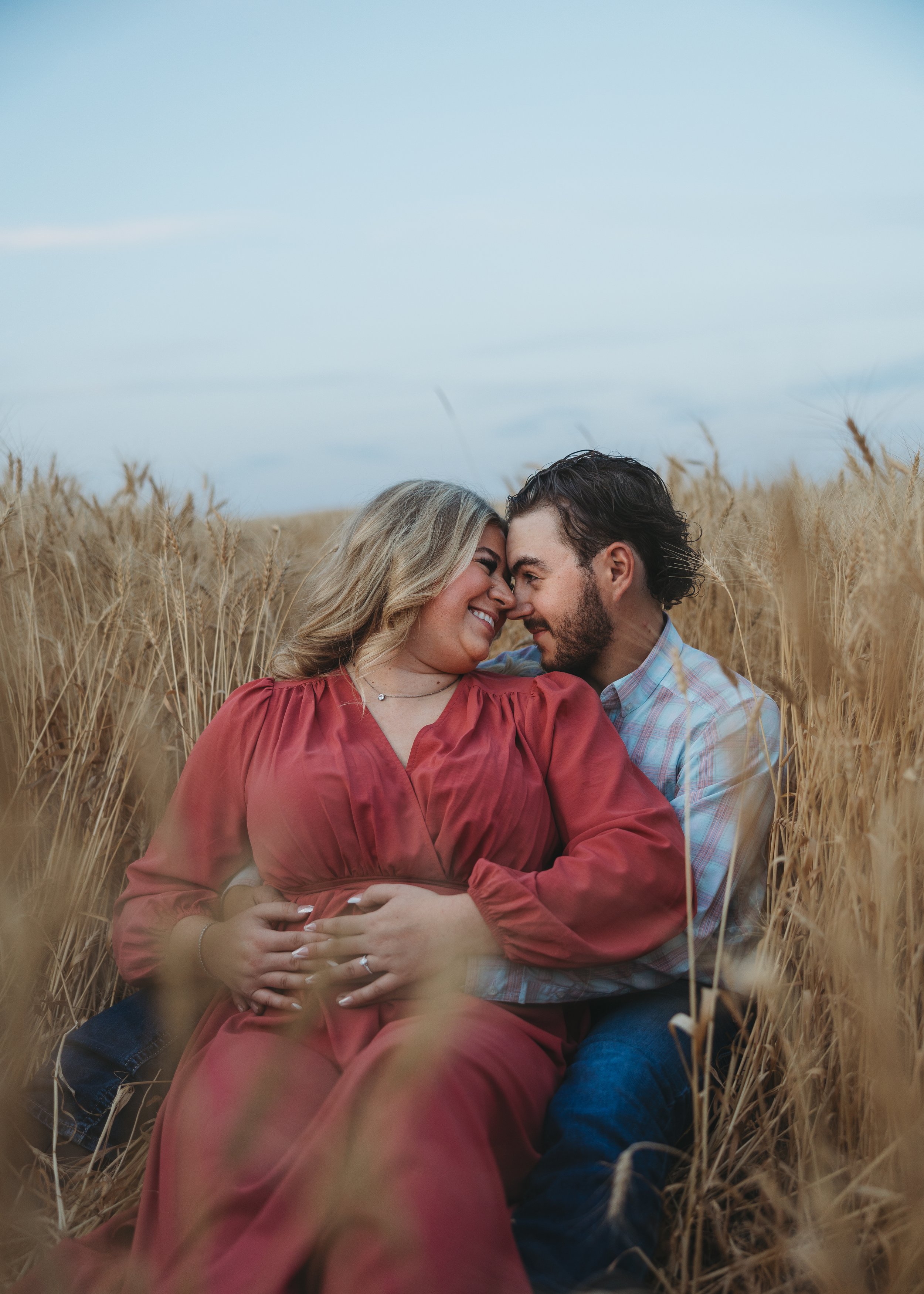 happy couple enveloped in corn field engagement session