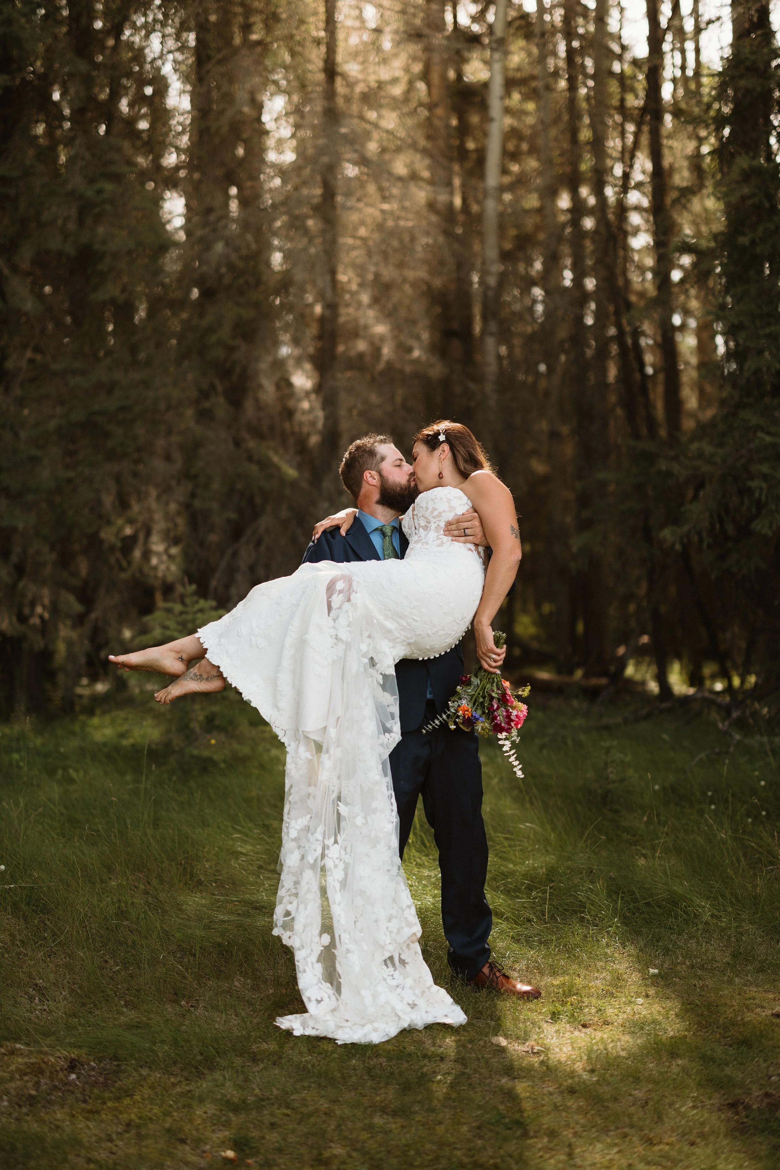 groom lifts bride at wedding in rocky mountain house