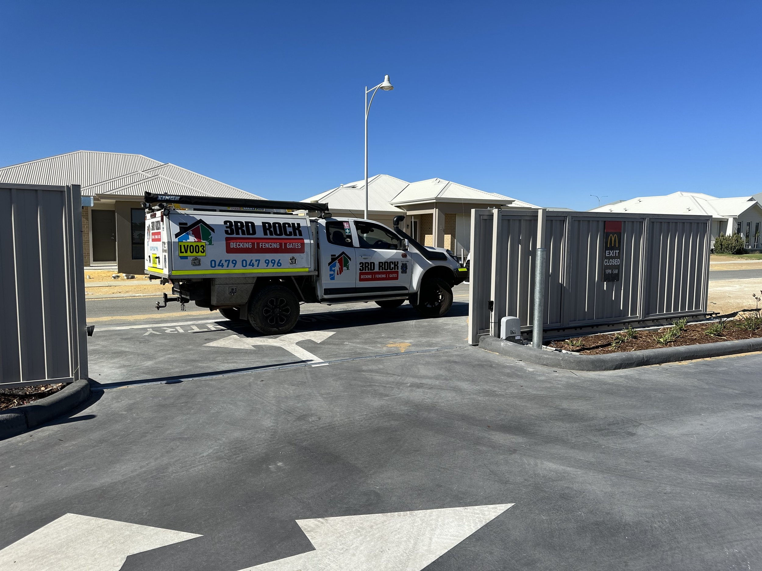 A construction vehicle parked outside a closed McDonald's restaurant with a sign indicating the exit is closed.
