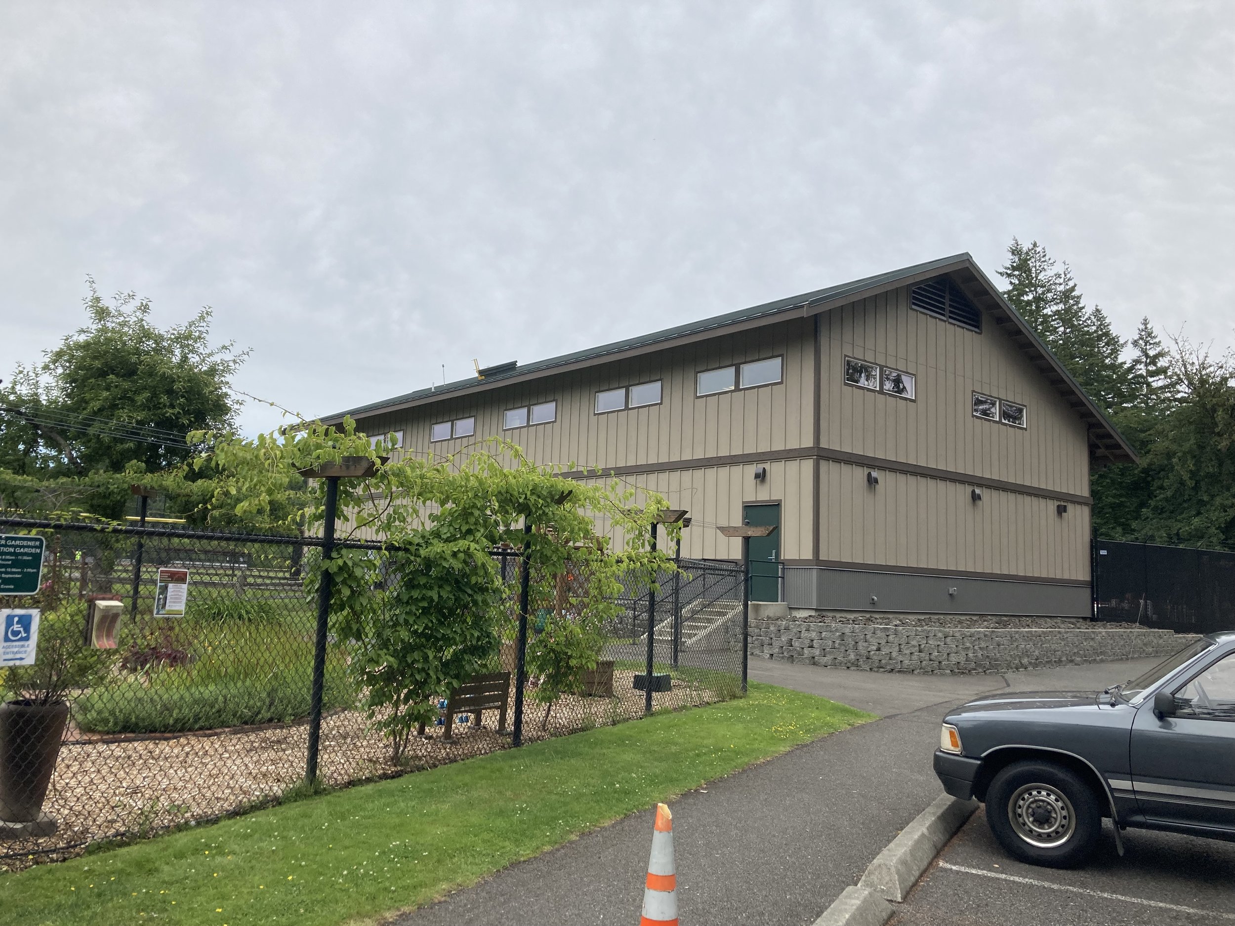 Sechmel Park maintenance building near the master gardener community garden surrounded by a black chain link fence