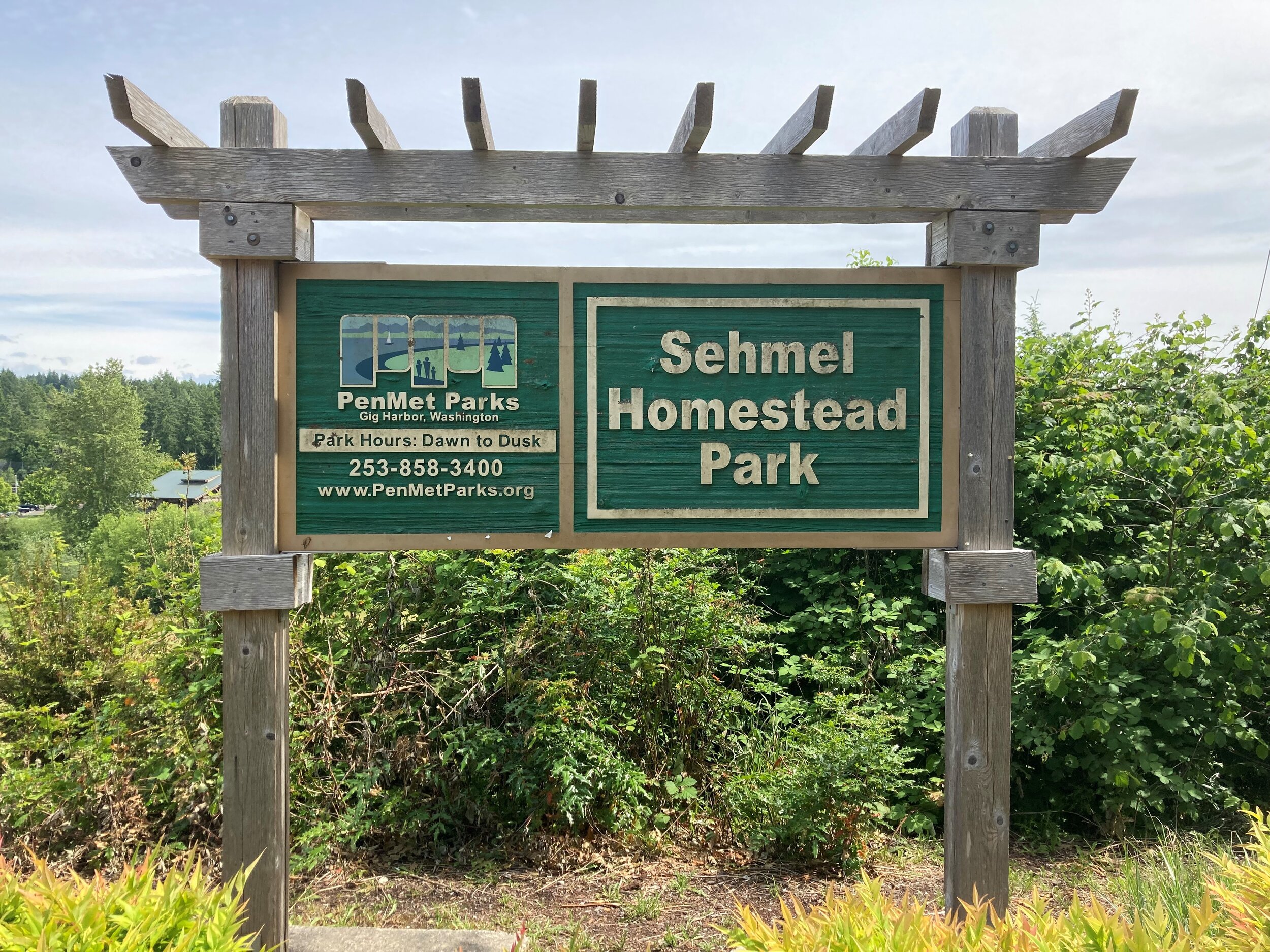 Sehmel Homestead Park entrance sign made of wood with a decorative top