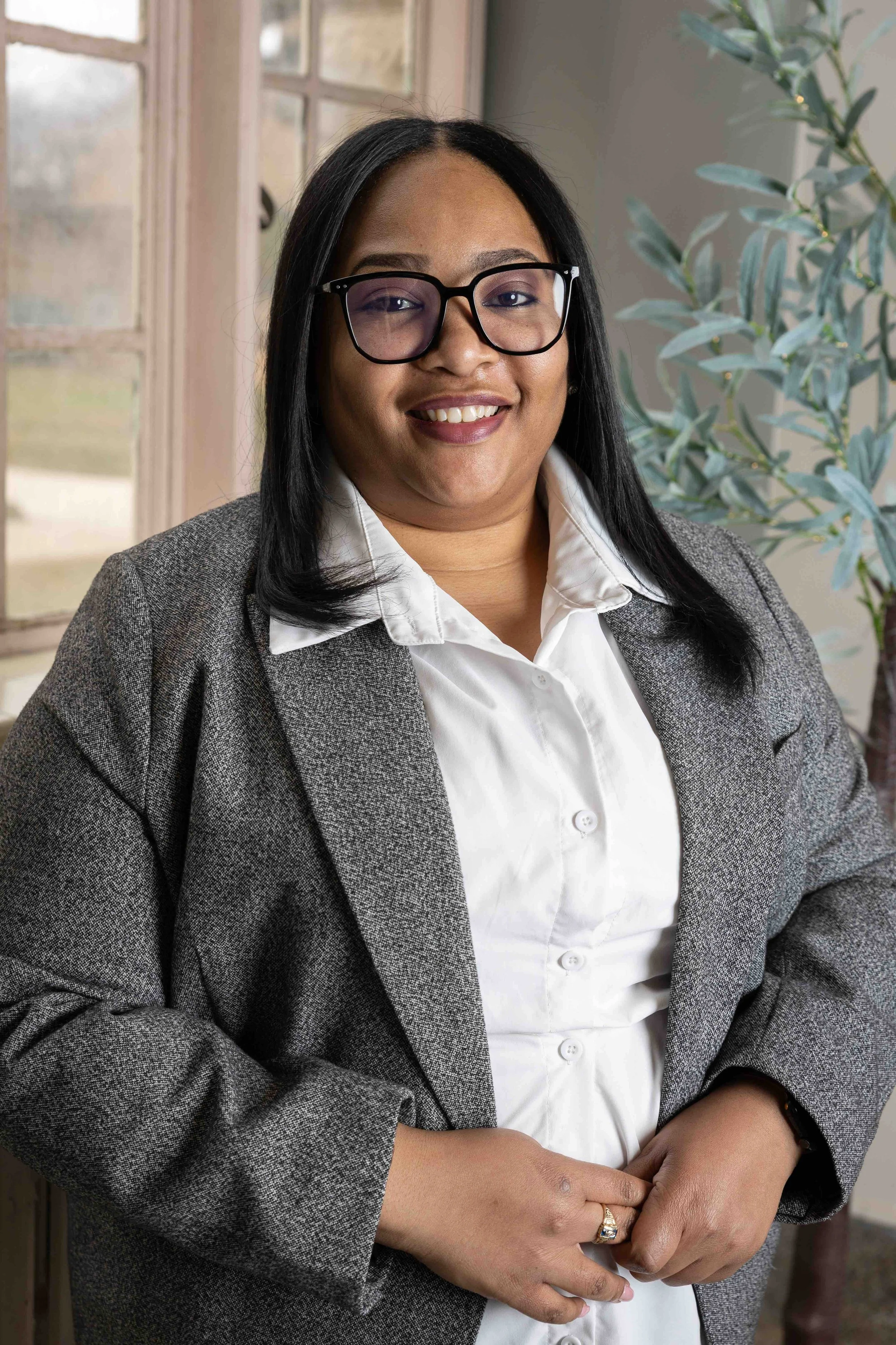 A business woman smiles and poses for her portrait by Lindsay Stayton