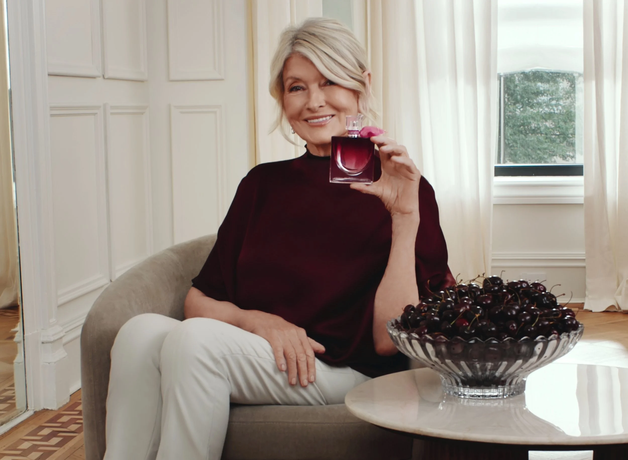 Martha Stewart holding Lancôme Very Cherry beside a bowl of cherries