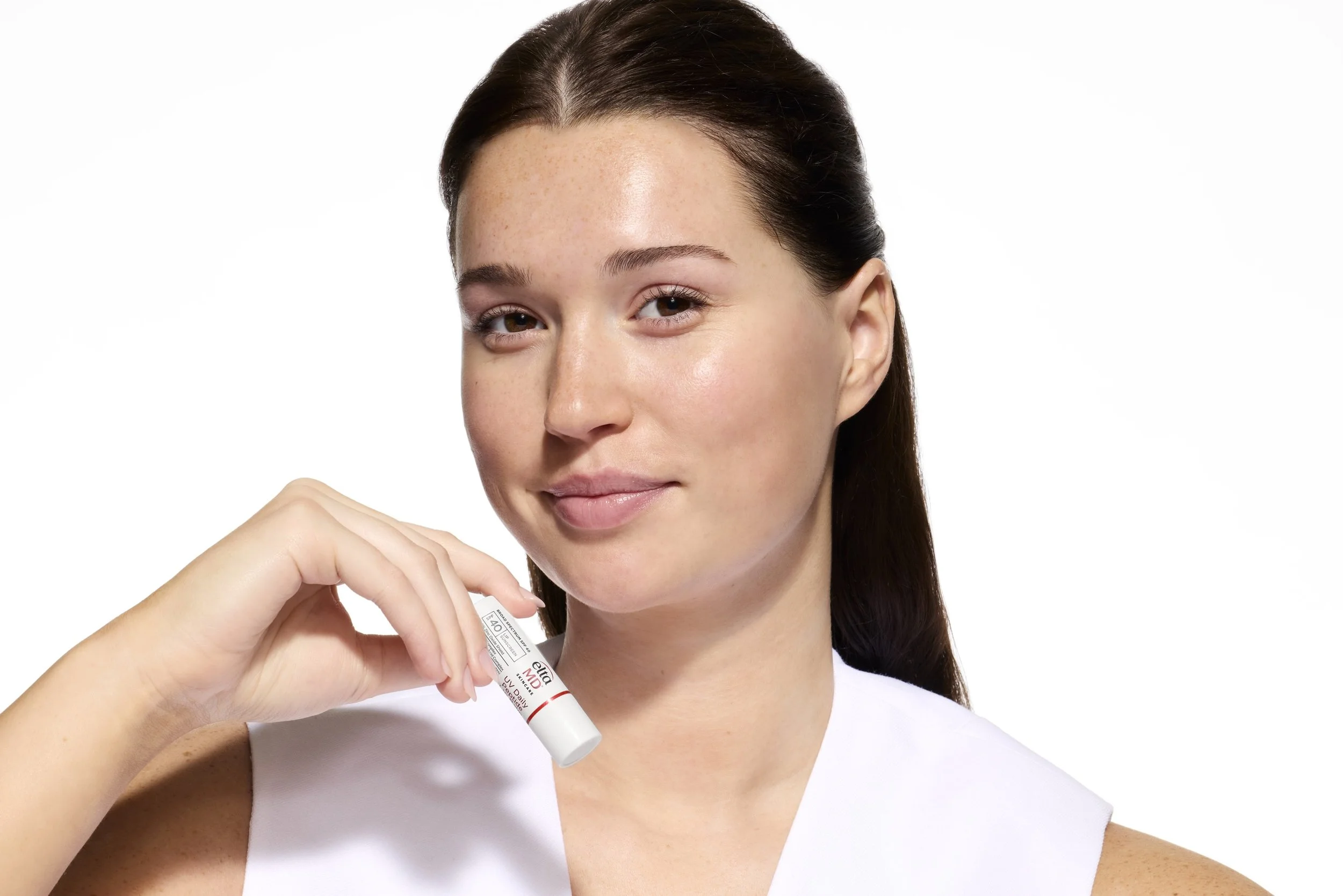 EMD_UVDailyPeptideLipBalm_Ella_HoldingPack.jpg