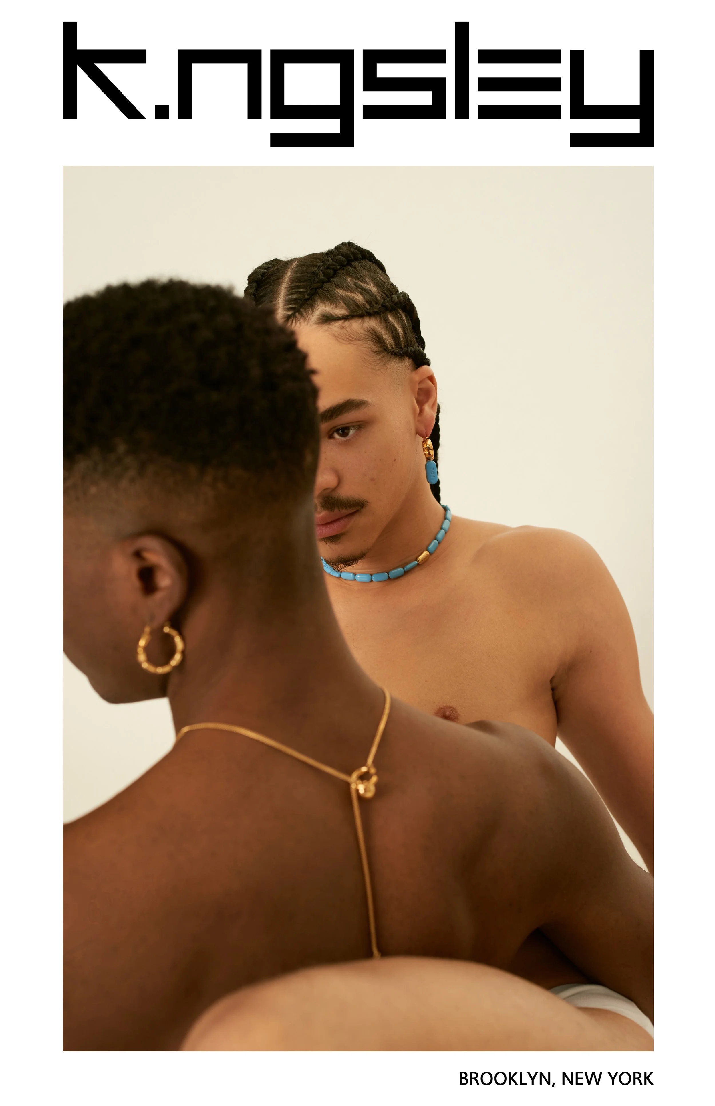 Two people with dark skin and braided hair and a mustache visible, wearing jewelry, looking at each other in a close embrace, Brooklyn, New York