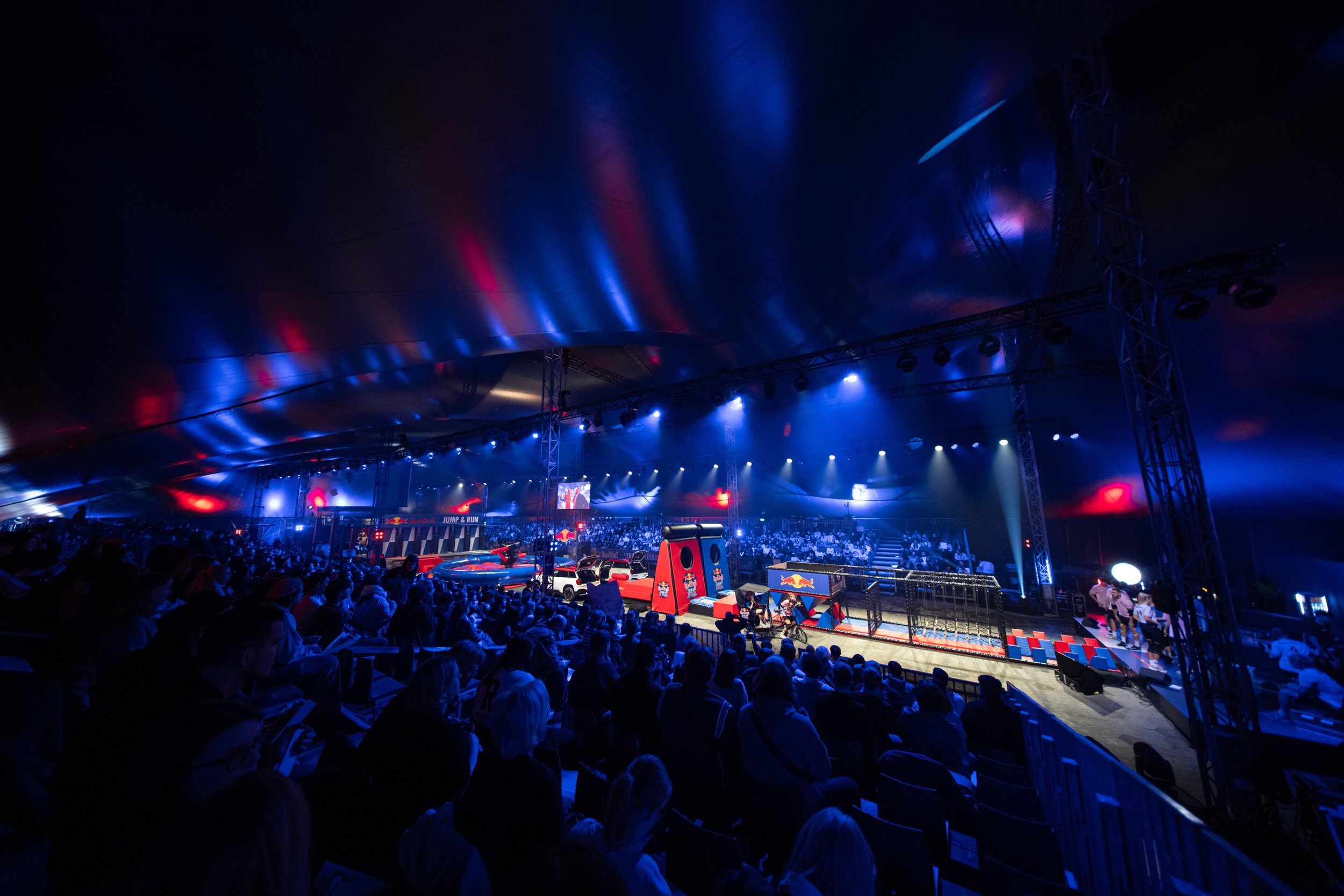 Obstacle course in a floodlit indoor arena with spectators at Red Bull Jump & Run 2026