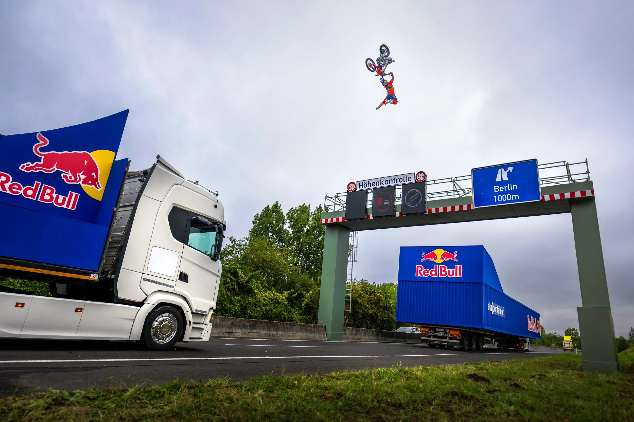 Luc Ackermann performing a never seen before freestyle motocross jump over a motorway gantry between two Red Bull trucks during the Bridge Traverse project