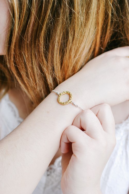 Gold circle bracelet in textured 18 carat gold vermeil with sterling silver chain on model by Militza Ortiz Jewellery