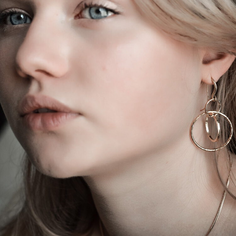 Circles dangling earrings in hammered gold with hook. Small size shown on model. By Militza Ortiz Jewellery