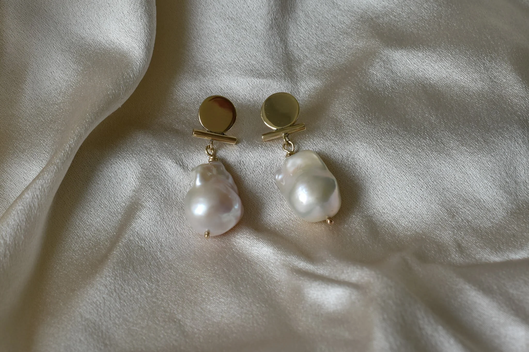 Gold circle and bar earrings with white baroque pearls on silk