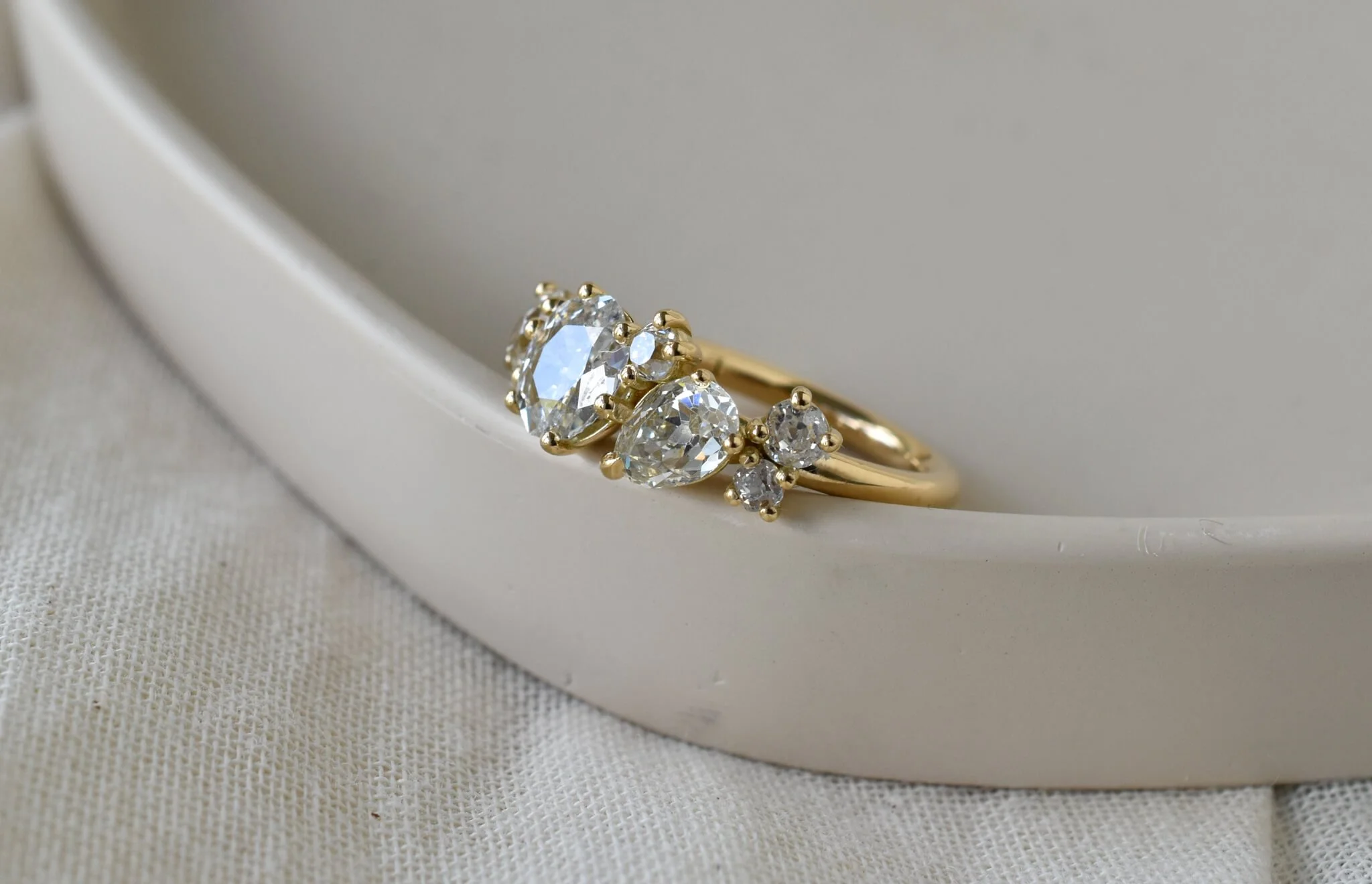 6 diamond gold ring leaning on beige dish