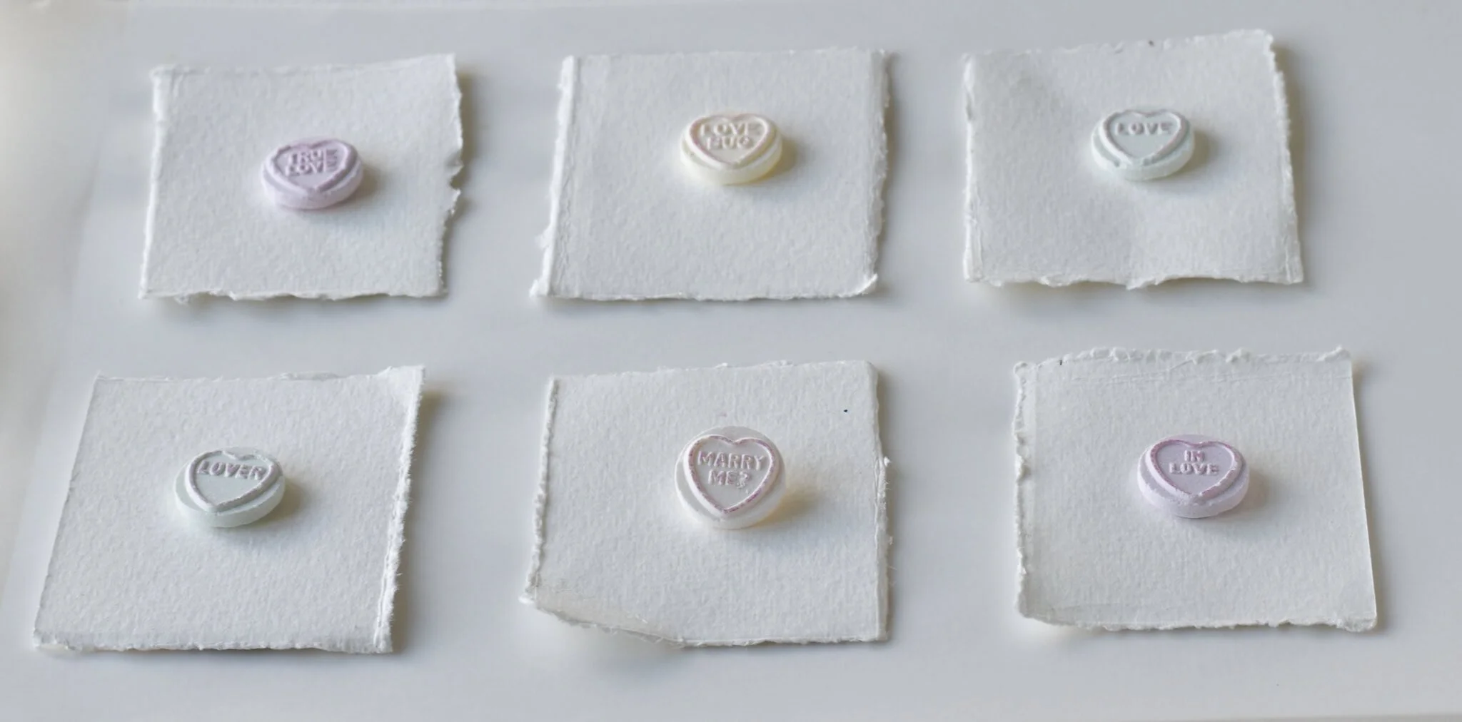Heart candies with love messages on cardboard