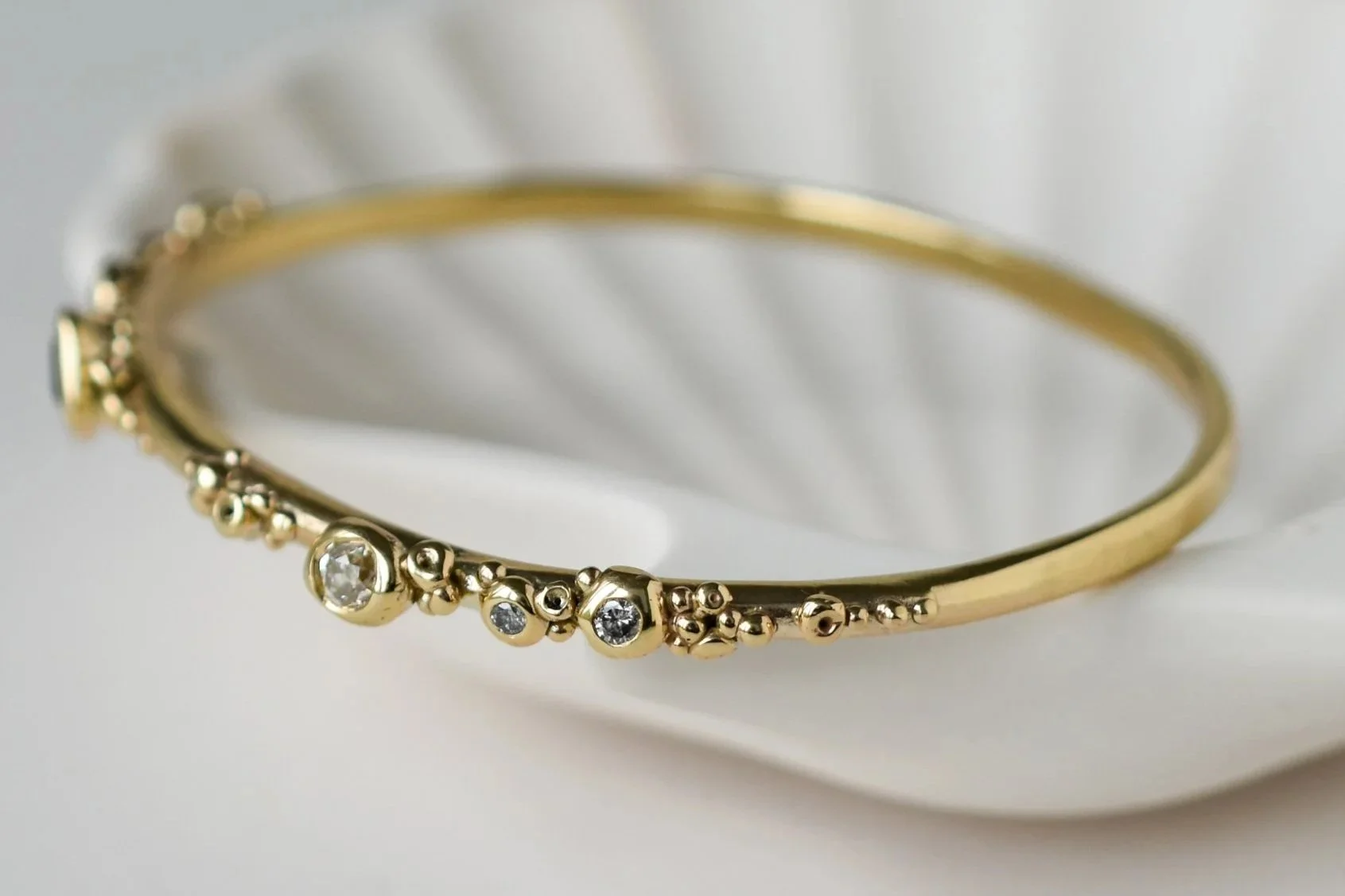9 carat yellow gold bangle with white and grey diamonds on shell