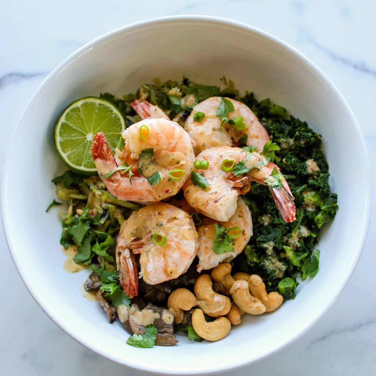 When I went into the kitchen to make lunch, I had no idea what I was going to have. This dish came together completely on the fly in between meetings! 
.
.
This is a Thai inspired shrimp stir fry bowl with kale, mushrooms, broccoli slaw and cashews. 