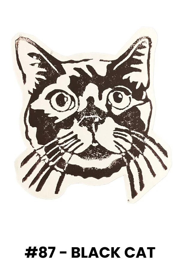 Stencil-style black and white illustration of a cat's face with pointy ears, large eyes, and distinctive markings, labeled "#87 - Black Cat."