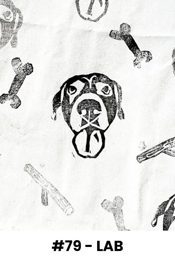 A black and white illustration of a dog's face with its tongue out, surrounded by various dog bones and chew sticks.