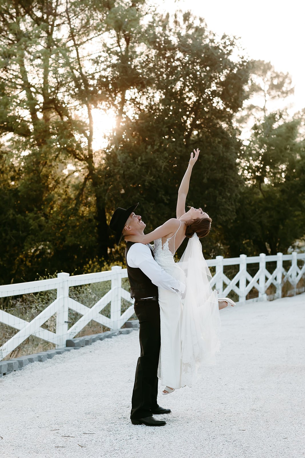 Bride and groom dancing and lifting during golden hour portrait at estate wedding