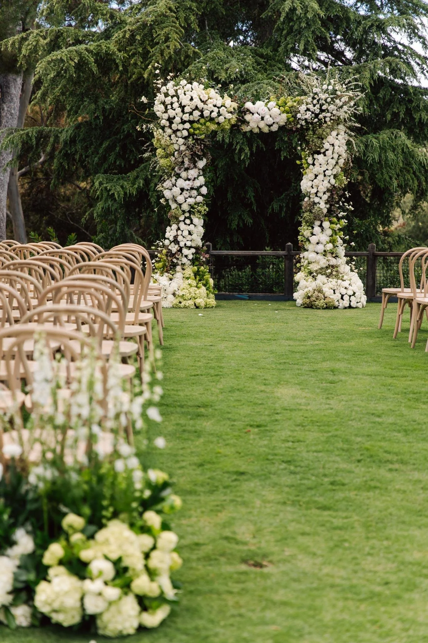 Ceremony aisle lined with white and green floral arrangements at private estate wedding in Rolling Hills Estates