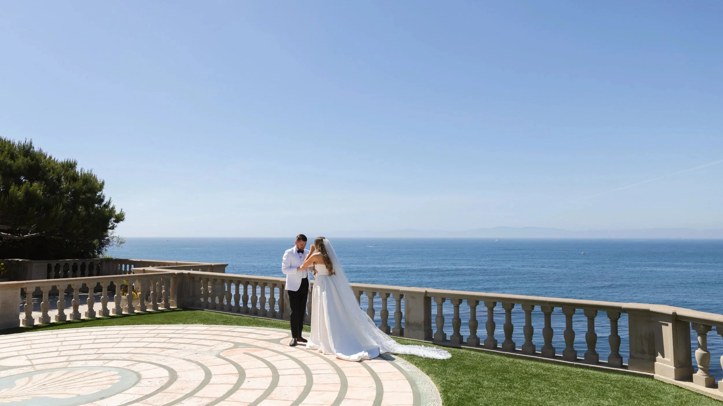 Bride and groom overlooking the Pacific Ocean at their coastal Palos Verdes wedding at The Neighborhood Church.