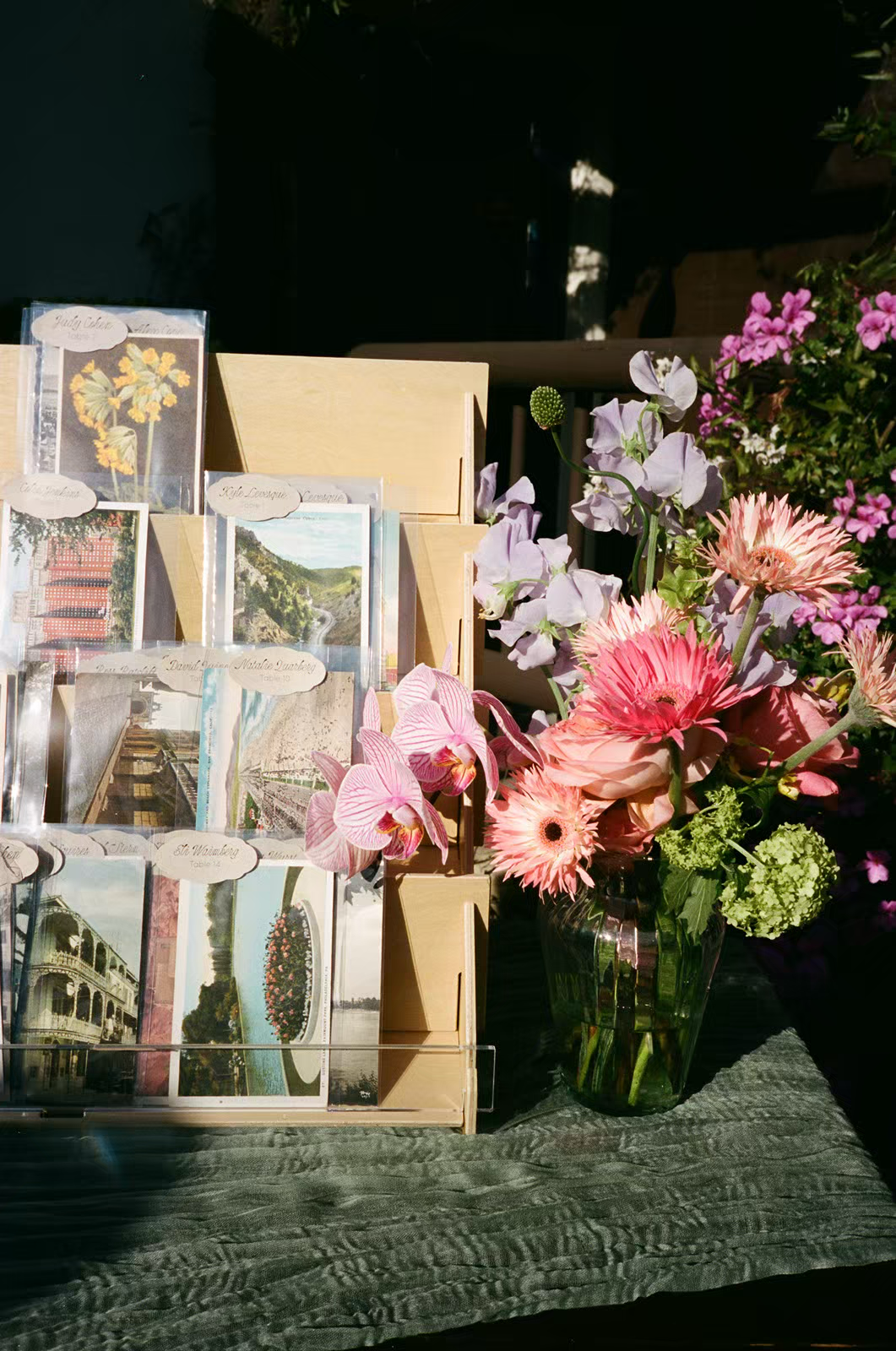a postcard display with vintage postcards and a colorful floral arrangement