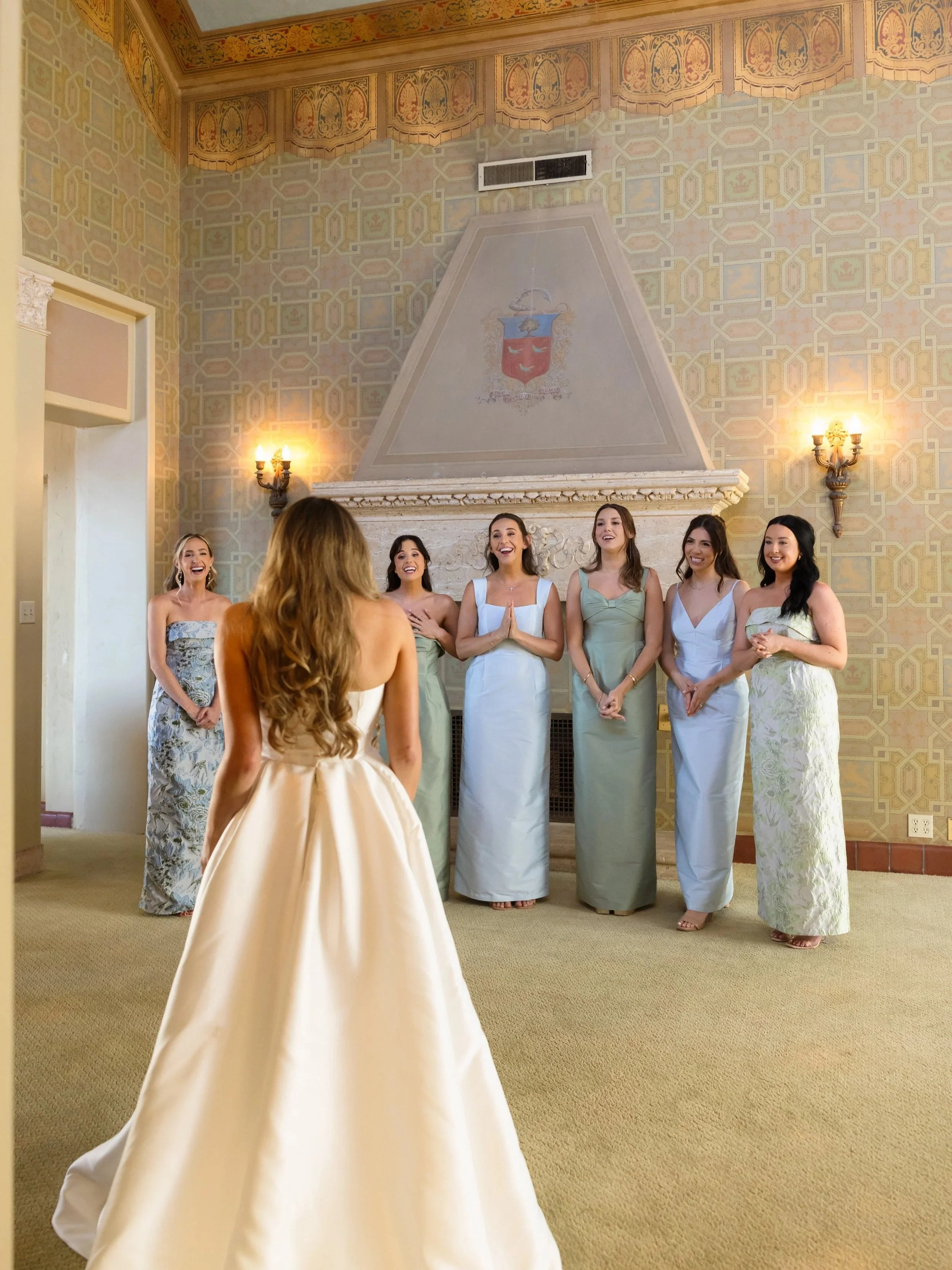 Bride seeing her bridesmaids in blue and green dresses before her Palos Verdes wedding.