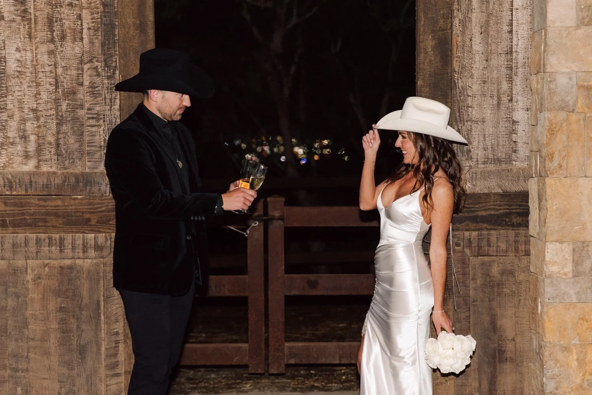 Bride and groom toasting champagne at private estate wedding in Rolling Hills Estates with rustic bar backdrop in horse stables.