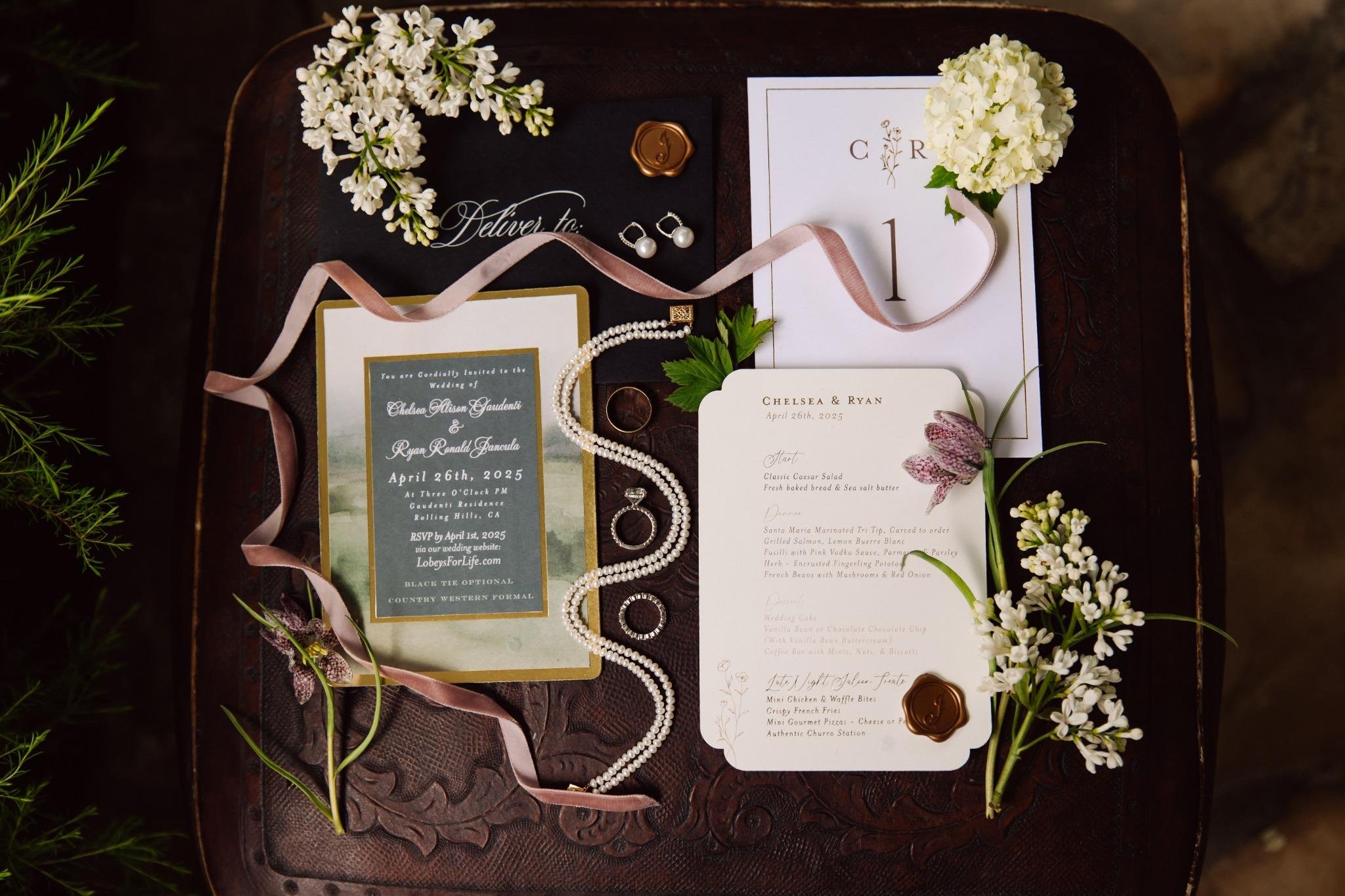 Wedding invitation suite flat lay with stationery, rings, and details from private estate wedding in Rolling Hills Estates